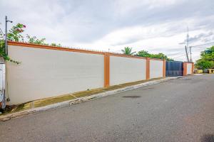 una cerca naranja y blanca al lado de una carretera en Casa de Estadía Verdún, en San José de Las Matas