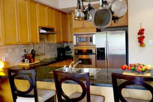 a kitchen with wooden cabinets and a stainless steel refrigerator at Stunning Rooms in Townhouse across the Beach in Toronto