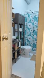 a bathroom with a toilet and a shower curtain at Sunset View 1-2 by Madriguera in La Libertad +9 photos