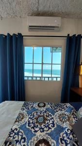 a bedroom with a bed and a large window at Sunset View 1-2 by Madriguera in La Libertad