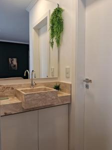 a bathroom with a sink and a mirror at Suíte confortável, churrasqueira e TV 55in em area nobre da cidade in Poços de Caldas