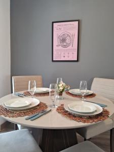 a table with plates and wine glasses on it at Suíte confortável, churrasqueira e TV 55in em area nobre da cidade in Poços de Caldas