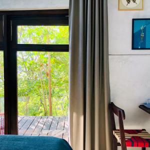 a bedroom with a sliding glass door with a window at The Hill Panama in Cambutal