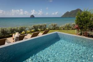 a swimming pool with a view of the ocean at Eden Roc Villas in Le Diamant