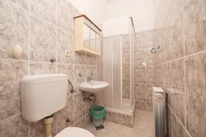 a bathroom with a toilet and a sink and a shower at Beachfront apartments Jermen in Sukošan