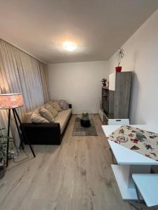 uma sala de estar com um sofá e uma mesa em Apartman LALA - Beograd, Surčin em Surčin