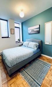1 dormitorio con 1 cama con pared azul en Niagara Suites en Niagara Falls