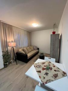 uma sala de estar com um sofá e uma mesa em Apartman LALA - Beograd, Surčin em Surčin
