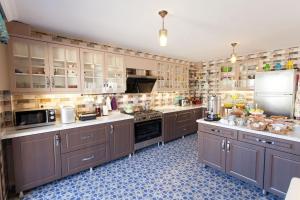 a large kitchen with brown cabinets and a refrigerator at Nilüfer Butik Otel in Ayvalık