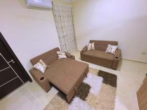 un soggiorno con 2 divani marroni e un tappeto di Beach Front Apartment in Hurghada La Quinta Beach Compound a Ismailia
