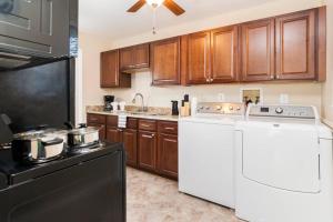 Una cocina con electrodomésticos blancos y gabinetes de madera. en Perfect for family visits to Washington DC or UMD!, en College Park
