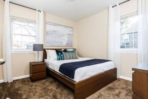 Un dormitorio con una cama y dos ventanas. en Perfect for family visits to Washington DC or UMD!, en College Park