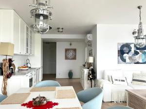 ウストロニエ・モルスキエにあるApartament Perłowy z BEZPOŚREDNIM WIDOKIEM na morze- Nadmorski Luksus Apartamentyのキッチン、リビングルーム(テーブル、椅子付)