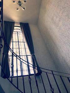 eine Treppe mit einem Fenster und einem Kronleuchter in der Unterkunft Posadas nido del tecolote in Guadalajara