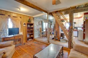 sala de estar con sofá, mesa y TV en Corral Creek Cow Camp Pet-Friendly Circle Cabin, en Circle