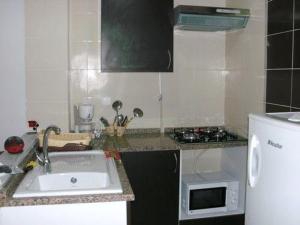 uma pequena cozinha com um lavatório e um micro-ondas em Holidays HOUSE em La Marsa