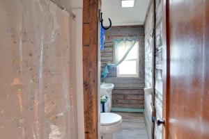 a bathroom with a toilet and a window at Corral Creek Cow Camp Pet-Friendly Circle Cabin in Circle +19 photos