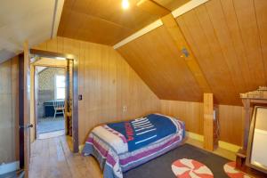 - une chambre avec un lit dans une pièce dotée de murs en bois dans l'établissement Corral Creek Cow Camp Pet-Friendly Circle Cabin, à Circle