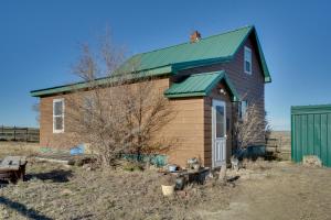 una pequeña casa con techo verde en Corral Creek Cow Camp Pet-Friendly Circle Cabin en Circle