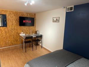 1 dormitorio con mesa y cartel en la pared en Studio proche forêt en Montmorency