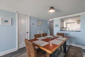 a dining room with a wooden table and chairs at Ocean Front D-Building - POOL ACCESS AND OCEAN VIEWS!!! in Harbor Island
