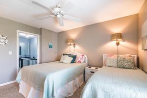 a bedroom with two beds and a ceiling fan at Ocean Front D-Building - POOL ACCESS AND OCEAN VIEWS!!! in Harbor Island