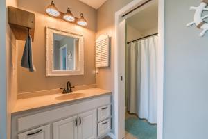 a bathroom with a sink and a mirror at Ocean Front D-Building - POOL ACCESS AND OCEAN VIEWS!!! in Harbor Island