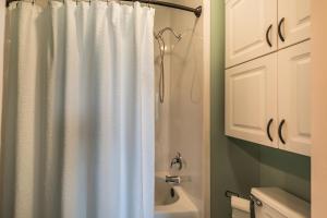 a bathroom with a shower curtain and a toilet at Ocean Front D-Building - POOL ACCESS AND OCEAN VIEWS!!! in Harbor Island