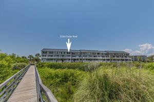 a boardwalk leading to a building on the beach at Ocean Front D-Building - POOL ACCESS AND OCEAN VIEWS!!! in Harbor Island