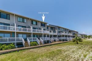 an exterior view of a hotel with beach chairs at Ocean Front D-Building - POOL ACCESS AND OCEAN VIEWS!!! in Harbor Island