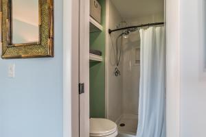 a bathroom with a toilet and a mirror and a shower at Ocean Front D-Building - POOL ACCESS AND OCEAN VIEWS!!! in Harbor Island