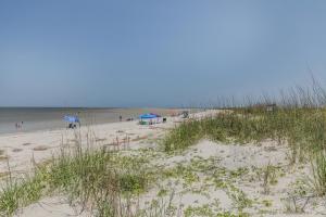 a beach with people and umbrellas and the ocean at Ocean Front D-Building - POOL ACCESS AND OCEAN VIEWS!!! in Harbor Island