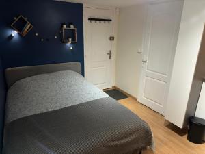 1 dormitorio con cama y pared azul en Studio proche forêt en Montmorency