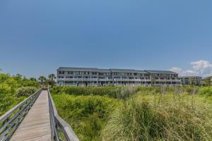a wooden boardwalk leading to a building on the beach at Ocean Front D-Building - POOL ACCESS AND OCEAN VIEWS!!! in Harbor Island
