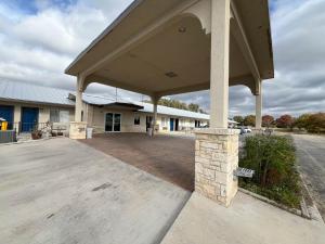 un aparcamiento vacío frente a un edificio en Motel 6 Junction, TX Llano River, en Junction