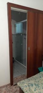 una puerta de cristal que conduce a una ducha en el baño en Quitinete no centro no segundo andar proxima a Rua das Pedras, en Búzios