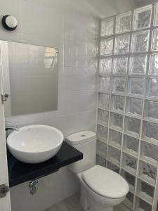 a white bathroom with a toilet and a sink at Apartamento Rota in Rota