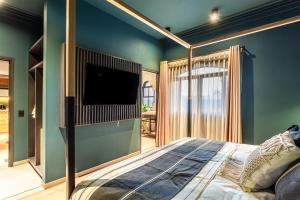 a bedroom with a bed with a tv on the wall at Casa Juarez in Puebla