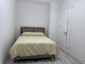a white bedroom with a bed and a door at Özlem my Home in Menemen