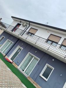 a blue house with a balcony on the side of it at Mare&Terra... Alloggi nel Delta in Polesine Camerini