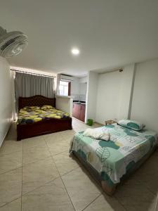 a bedroom with two beds and a kitchen at Casona La Española in Cartagena de Indias
