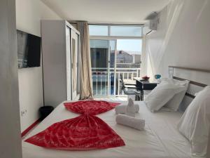 a bedroom with a bed with a red dress on it at Hotel Principal in Tarrafal