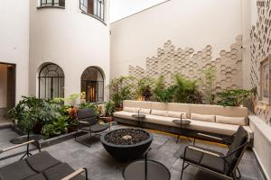 a lobby with a couch and chairs and plants at Casa Juarez in Puebla