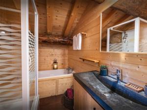 La salle de bains est pourvue d'un lavabo et d'une baignoire. dans l'établissement Chalet Capieu - Le Barn - OVO Network, à Manigod