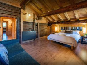 - une chambre avec un lit et un canapé dans l'établissement Chalet Capieu - Le Barn - OVO Network, à Manigod