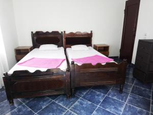 科布萊蒂的住宿－Зелёный дом у моря，配有粉红色床单的客房内的两张床