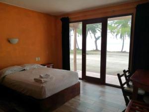 a bedroom with a bed and a sliding glass door at Xcalak Caribe Lodge in Xcalak