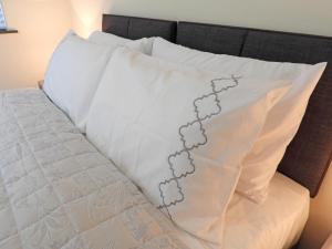 a white pillow with a flower pattern on it on a bed at A Home from Home - Leamington Spa in Leamington Spa