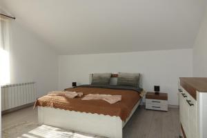 1 dormitorio con cama y pared blanca en Къща за гости "При Николови" en Beden