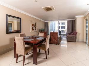 a dining room with a table and chairs at Stunning Sails on Point C208 in Durban
